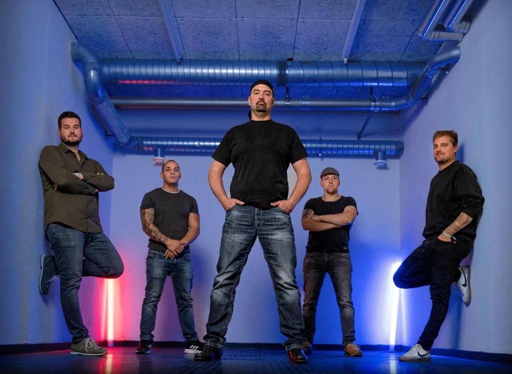 Die fünf Musiker von Red Queen in einem Gang mit roter und blauer Neonröhre